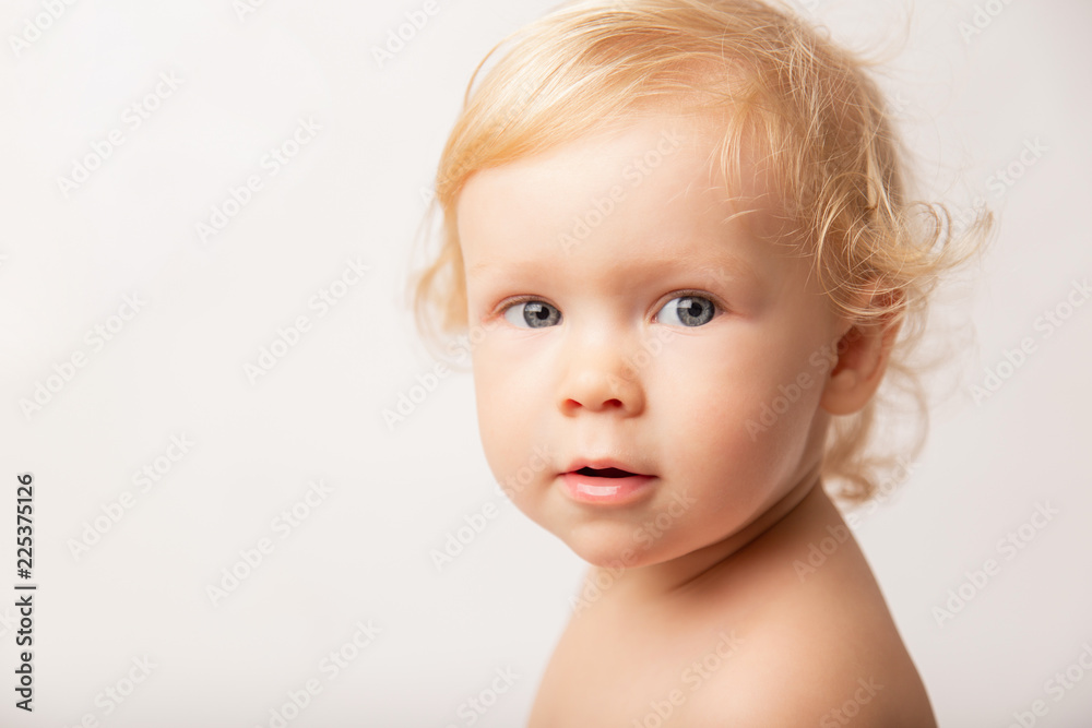 portrait of a little baby girl with blue eyes and curly hair, on a white background, closeup. concept childhood portrait of a little baby girl with blue eyes and curly hair, on a white background, closeup. concept childhood