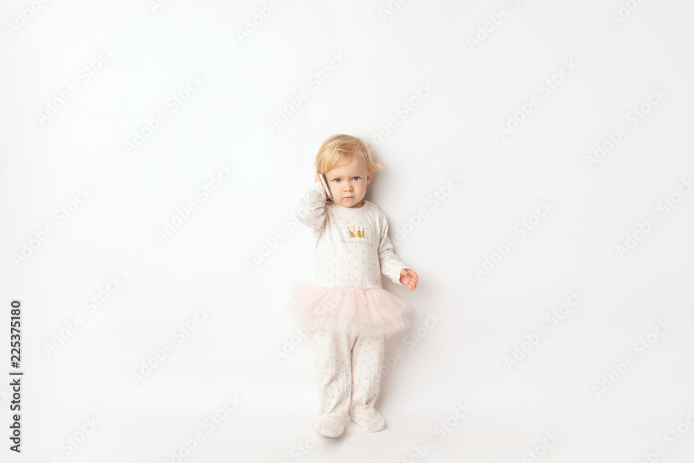 Little blond Girl with Mobile Phone Isolated on White Background. concept a new generation or children and technology