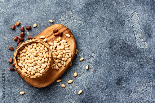 Quadro su tela Peeled pine nuts with copy space on gray background. Top view.