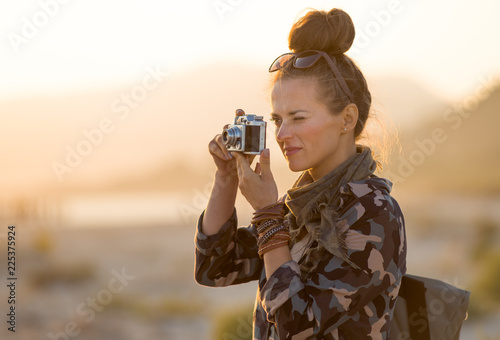 traveller woman taking photos with retro photo camera