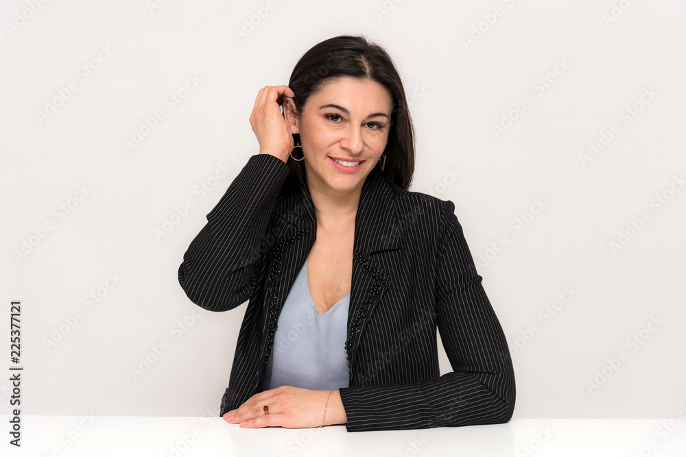 Portrait of a beautiful brunette woman on a white background with different emotions sitting at the table. Portrait of a beautiful brunette woman on a white background with different emotions sitting at the table.