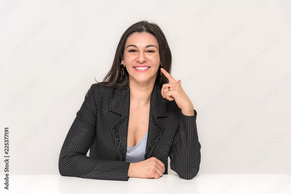 Portrait of a beautiful brunette woman on a white background with different emotions sitting at the table. Portrait of a beautiful brunette woman on a white background with different emotions sitting at the table.