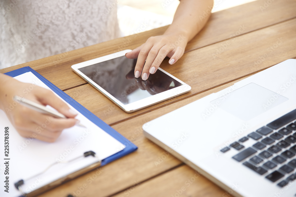 Woman hand writing and touching digital tablet Young girl studying outdoor. Cropped shot. Woman hand writing and touching digital tablet Young girl studying outdoor. Cropped shot.