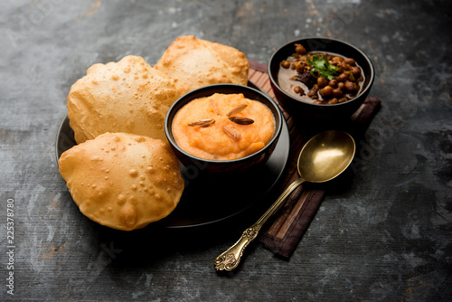 Konstfotografi Suji/Sooji Halwa Puri or Shira Poori with black chana masala breakfast, served in a plate and bowl