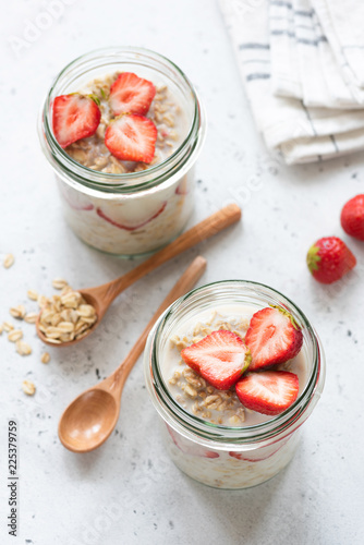 Overnight oatmeal or strawberry overnight oats in a jar on concrete background. Selective focus, healthy eating and lifestyle concept