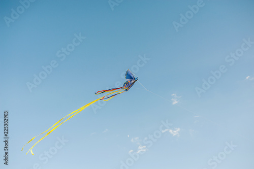 Multi-colored kite against the background of the blue sky