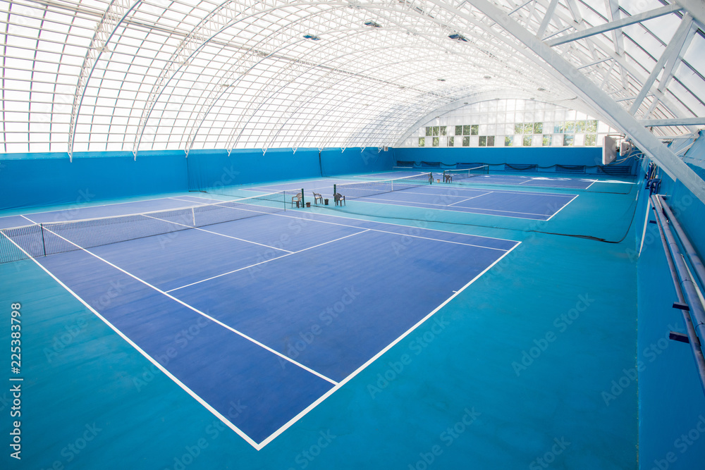 Background shot of modern indoor tennis court interior in blue colors, copy space - obrazy, fototapety, plakaty 