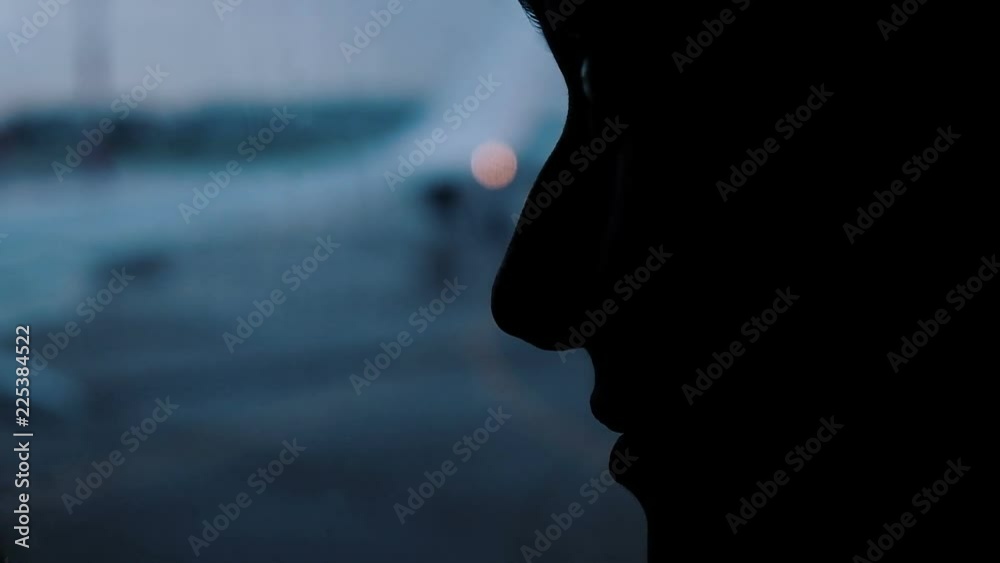 Silhouette of a female face in the shadow of a close-up. A girl looks in the wet window at the airport on airplanes, slow motion Silhouette of a female face in the shadow of a close-up. A girl looks in the wet window at the airport on airplanes, slow motion