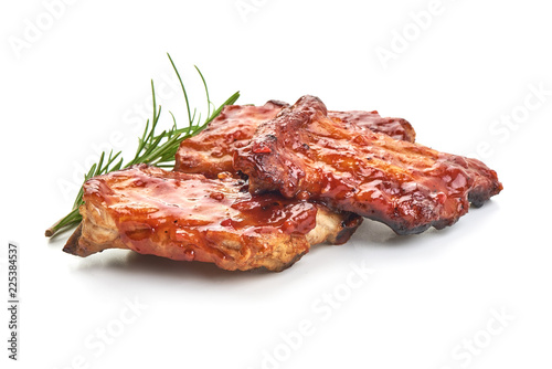 Fototapeta Delicious grilled pork ribs in BBQ sauce with herbs, isolated on white background