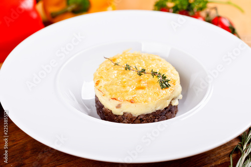 Shepherd's pie. Traditional British dish with minced meat, mashed potatoes and cheese on white plate. Close up