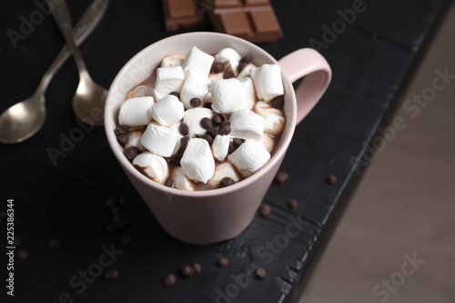 Tasty hot chocolate with milk and marshmallows in cup on table © New Africa