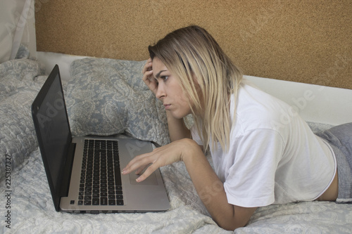 young girl with computer in bed photo