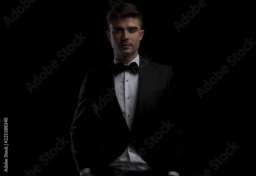 portrait of relaxed young man wearing a black tuxedo