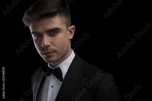 portrait of young stylish man wearing black tuxedo and bowtie
