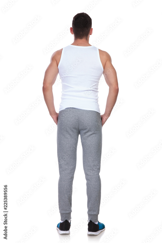 rear view of fitness man standing with hands in pockets rear view of fitness man standing with hands in pockets