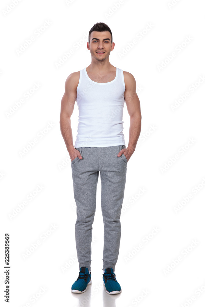 handsome man wearing white top standing with hands in pockets handsome man wearing white top standing with hands in pockets