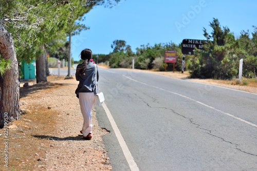 young woman walking on country road