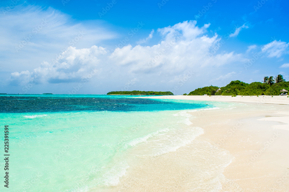 Naklejka premium Beautiful sandy beach with sunbeds and umbrellas in Indian ocean, Maldives island