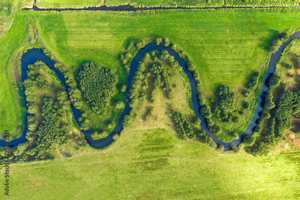 Aerial view on winding river in rural landscape - obrazy, fototapety, plakaty 
