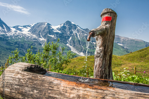 Photos water tap in a wooden stump in grossglockner austria