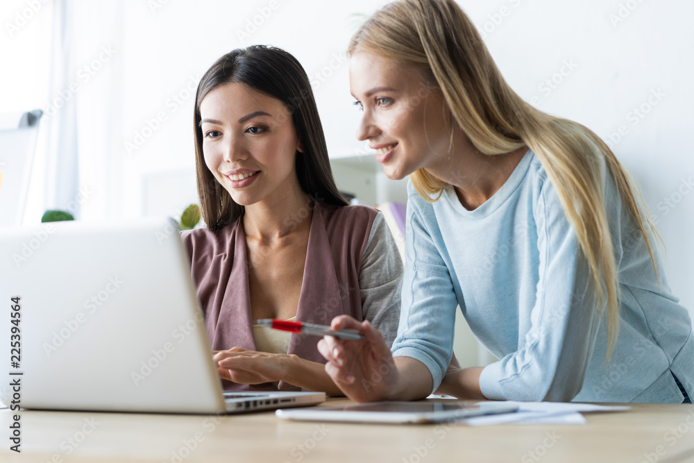 Two female colleagues in office working together. Two female colleagues in office working together.