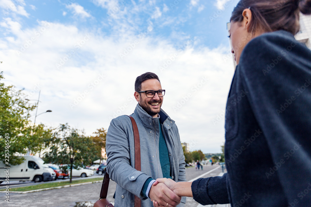 Naklejka premium Businessman and businesswoman are handshaking outdoor
