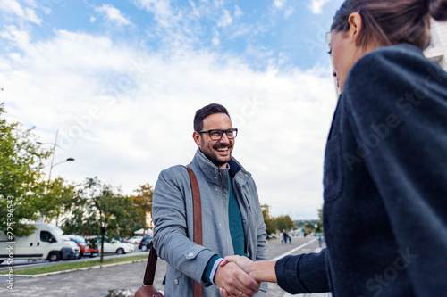 Businessman and businesswoman are handshaking outdoor