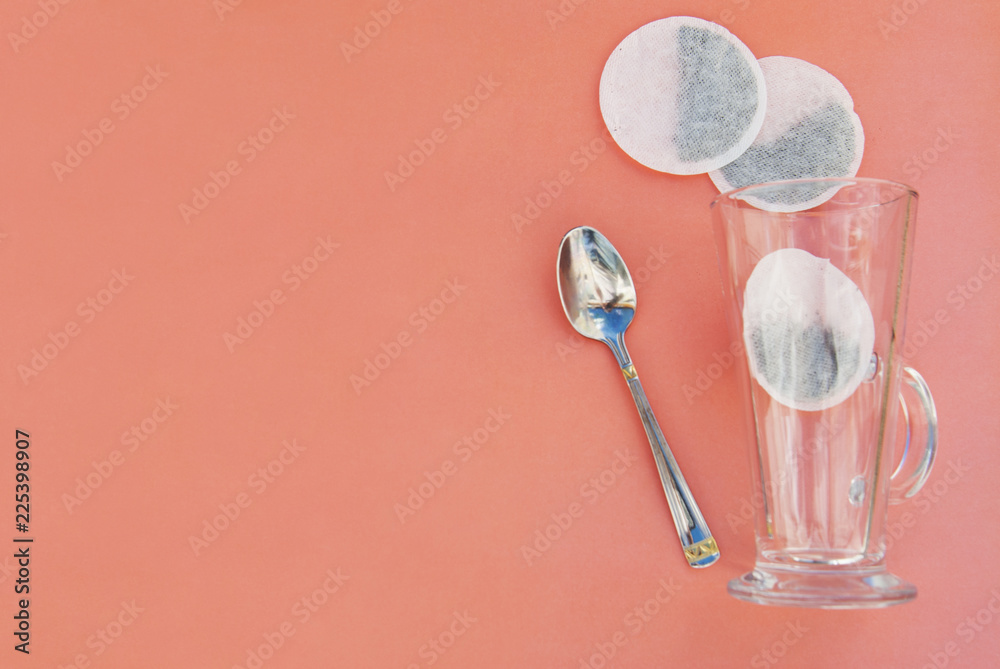 Top view of one tea bag and empty glass cup isolated on pink. Top view of one tea bag and empty glass cup isolated on pink.