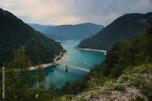A view into the Piva lake (Pivsko jezero) going through a valley with an old rusty bridge connecting both shores. Municipality Plužine, Montenegro. © JuliusLakatos