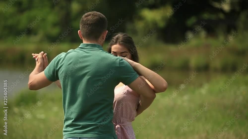 Beautiful couple dance in the field. the enjoy each other and smile. Summer weather. Romantic atmophere. slow motion Beautiful couple dance in the field. the enjoy each other and smile. Summer weather. Romantic atmophere. slow motion