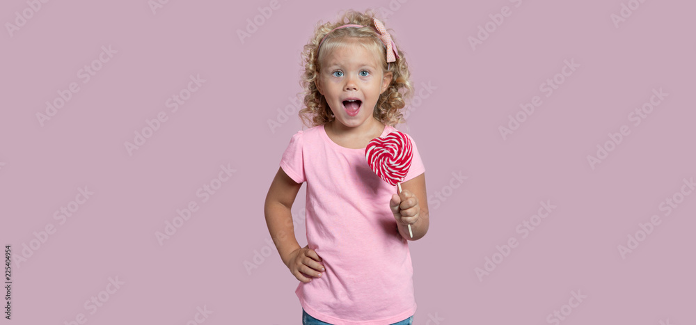 Cute baby girl with green eyes and lalypop isolated over pink background Cute baby girl with green eyes and lalypop isolated over pink background
