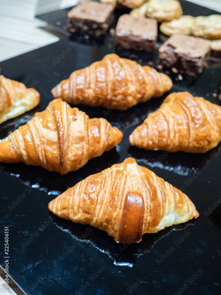 Assortment of delicious and buttery croissants made by pastry chef. All look very tasty and delightful. Natural light.
