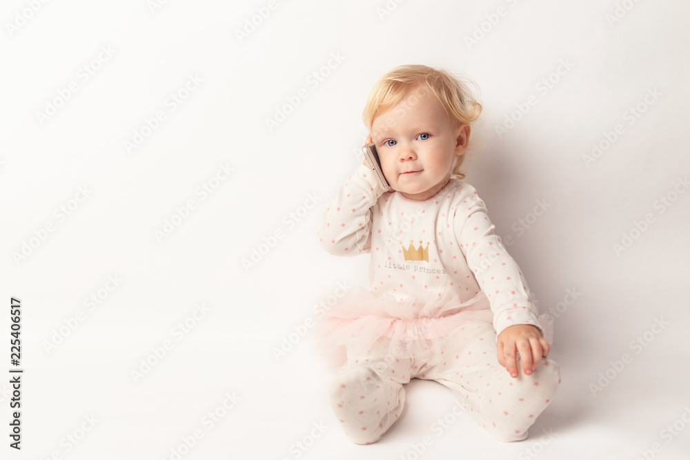 Little blond Girl with Mobile Phone Isolated on White Background. concept a new generation or children and technology Little blond Girl with Mobile Phone Isolated on White Background. concept a new generation or children and technology