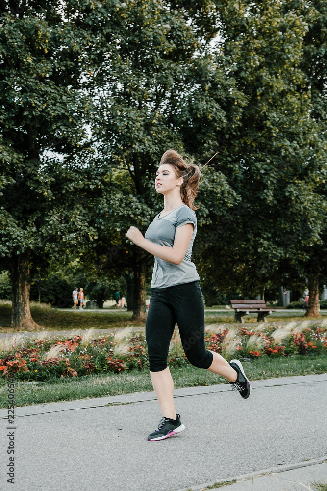 A young and beautiful girl doing outdoor sports. In the park the girl performs sports exercises. A young and beautiful girl doing outdoor sports. In the park the girl performs sports exercises.