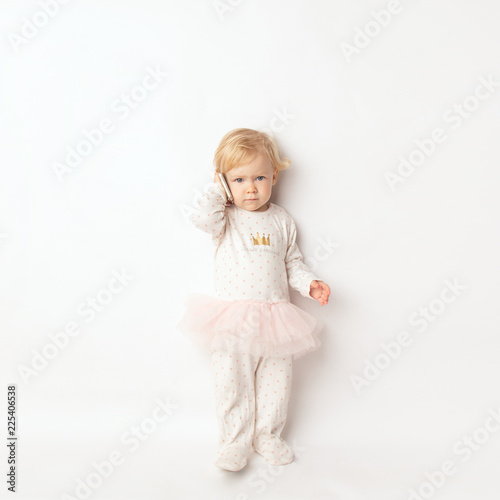 Little blond Girl with Mobile Phone Isolated on White Background. concept a new generation or children and technology