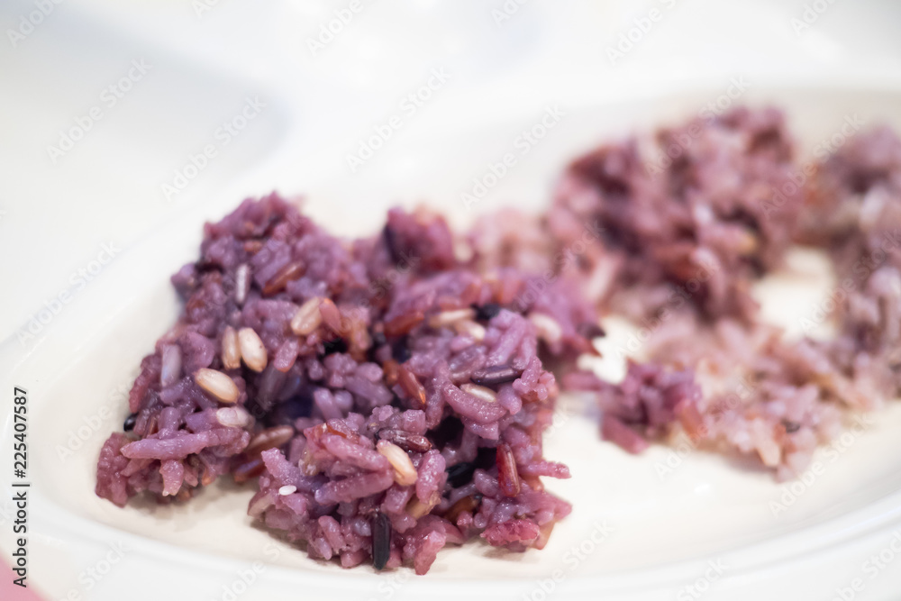 Close up of freshly cooked purple or black rice on a white plate. High in nutrients and good source of vitamin, mineral, antioxidant, anthocyanin, high in fiber. Healthy eating and eat well concept. Close up of freshly cooked purple or black rice on a white plate. High in nutrients and good source of vitamin, mineral, antioxidant, anthocyanin, high in fiber. Healthy eating and eat well concept.