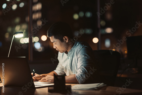 Businessman working at his desk at night photo