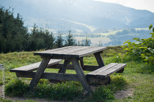  closeup of wooden picnic table in mountain landscape background photo