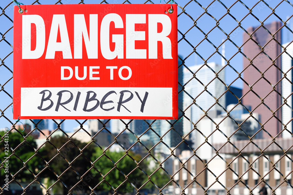 Sign danger due to bribery hanging on the fence Sign danger due to bribery hanging on the fence
