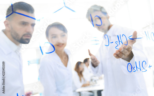 group of laboratory scientists discussing their research in the laboratory.