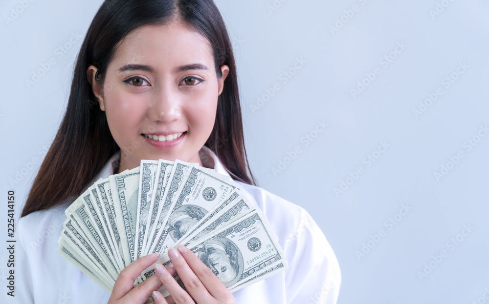 Cheerful smiling young woman holding money dollars in her hand looking at camera on white background. Cheerful smiling young woman holding money dollars in her hand looking at camera on white background.