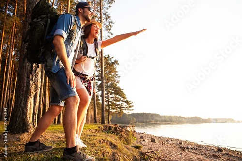 Happy couple going on a hike together in a forest.