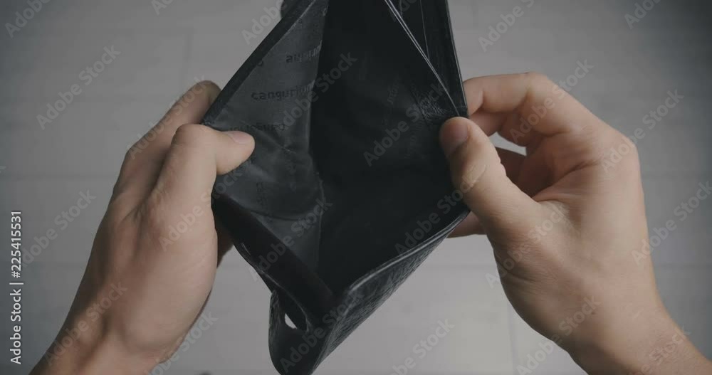 Close-up of a man's hand holding Leather Wallet Empty with No Money. The concept of poverty