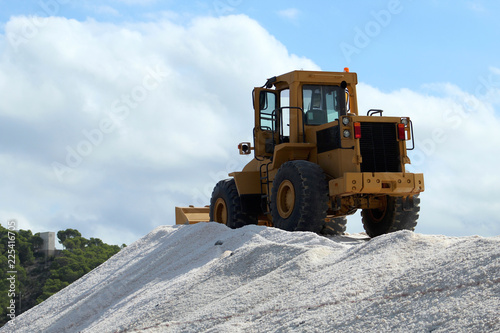 Bulldozer on salt mountain in industrial salt marsh