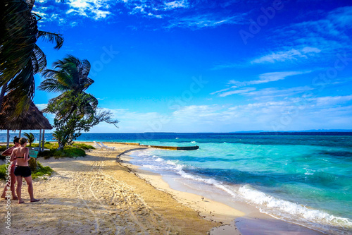 Photos A pair of tourists walk on the golden sand of the tiny island of Rendezvous Caye