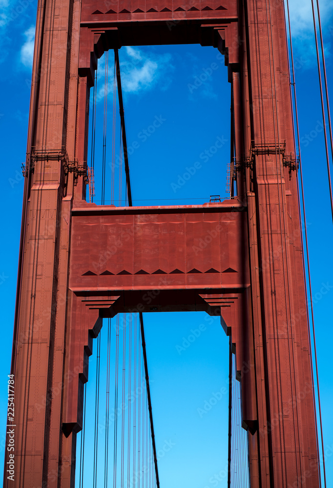 Fototapeta premium Golden Gate Bridge, San Francisco - red steel structure against bright blue sky