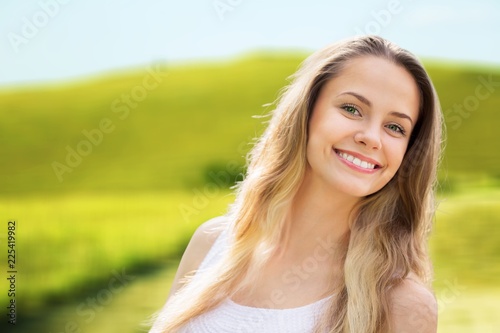 Young relaxed woman on blurred nature background