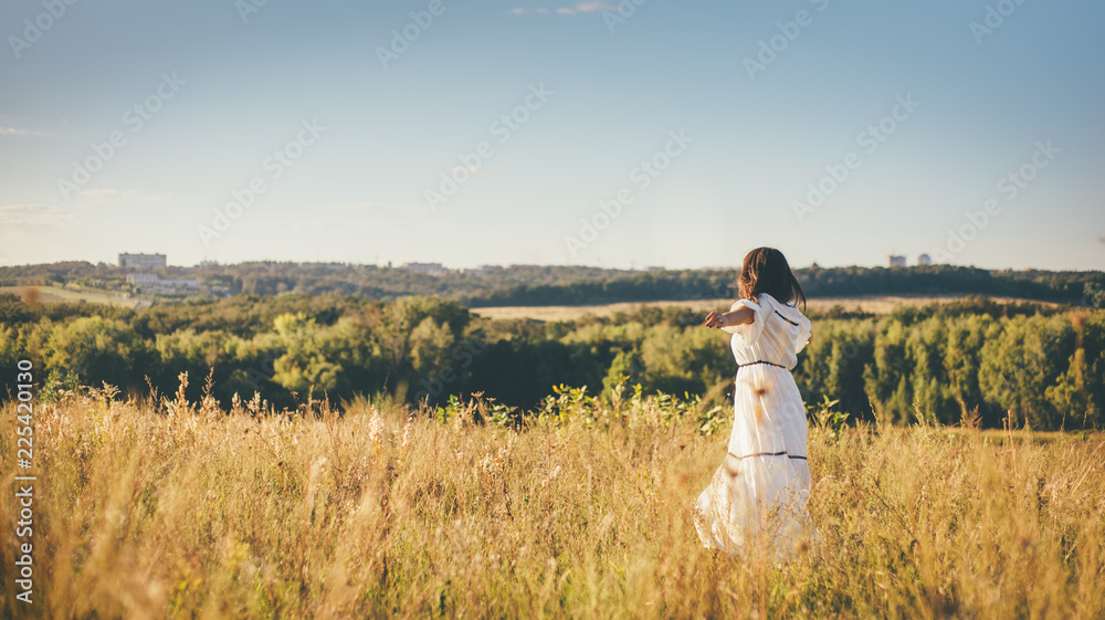 beautiful young woman is running on the hill field