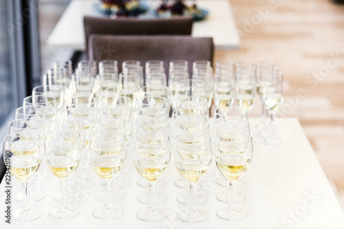 Full cold champagne flutes stand between buckets on dinner table