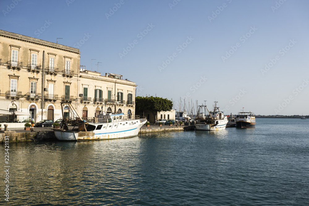View to the ocean from fishing boats at the jetty on Ortigia Island, Syracuse, Sicily, Italy